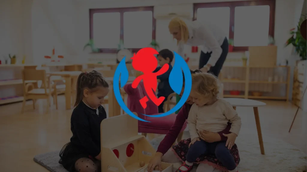 Two young girls play with toys on the floor in a bright classroom, while an adult and another child engage in the background. A red and blue childcare logo is overlaid on the image.
