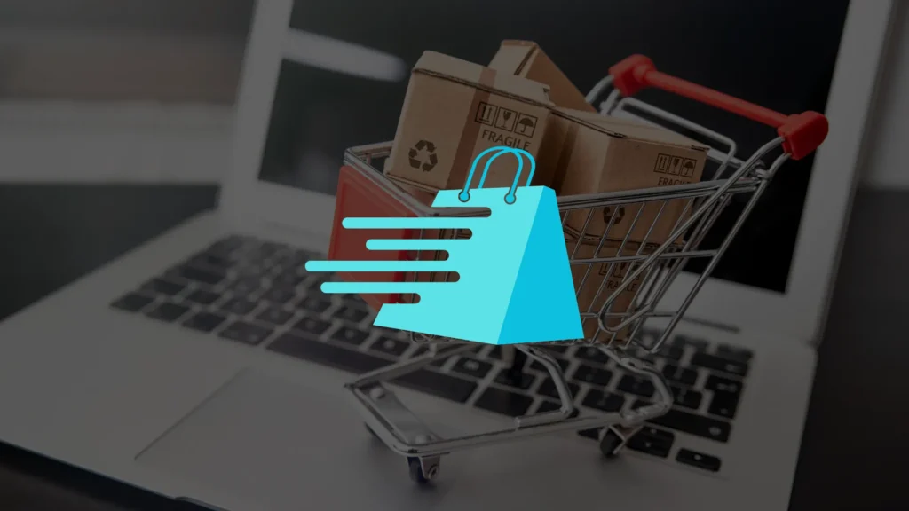 A miniature shopping cart with cardboard boxes sits on a laptop keyboard, symbolizing online shopping. A blue shopping bag icon with speed lines is overlaid on the image.