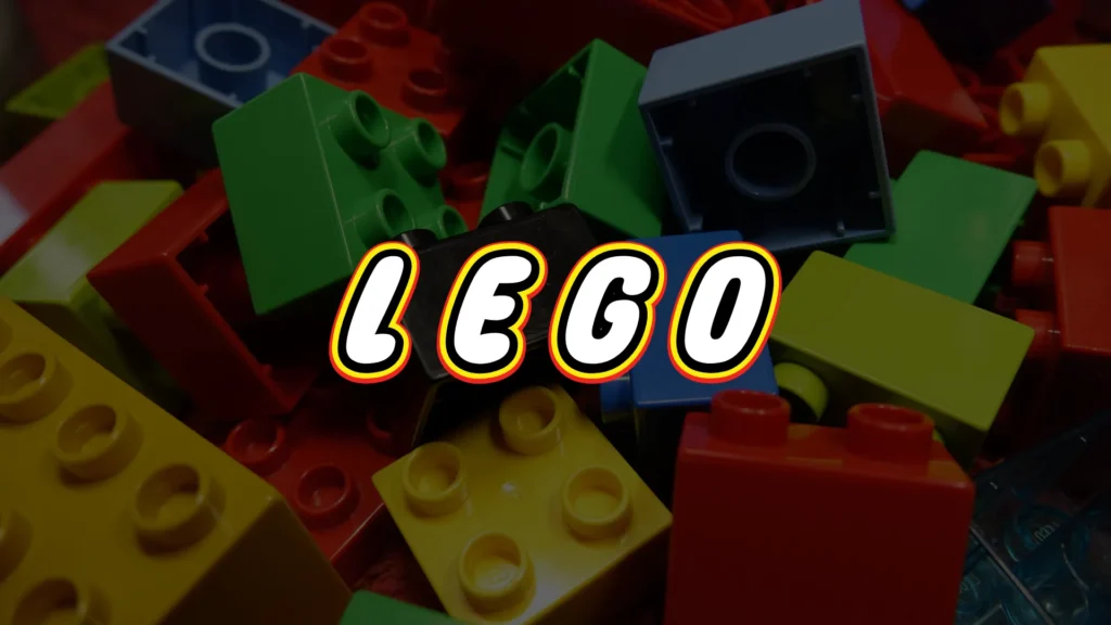 A colorful pile of LEGO bricks in red, green, yellow, and black, with the word LEGO in bold white letters outlined in black, yellow, and red across the center.