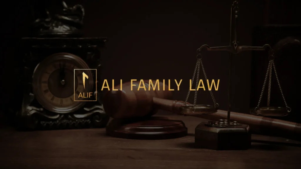 A wooden gavel, a balance scale, and an ornate clock sit on a desk with the text ALI FAMILY LAW and a logo reading ALIF in gold letters in the center.